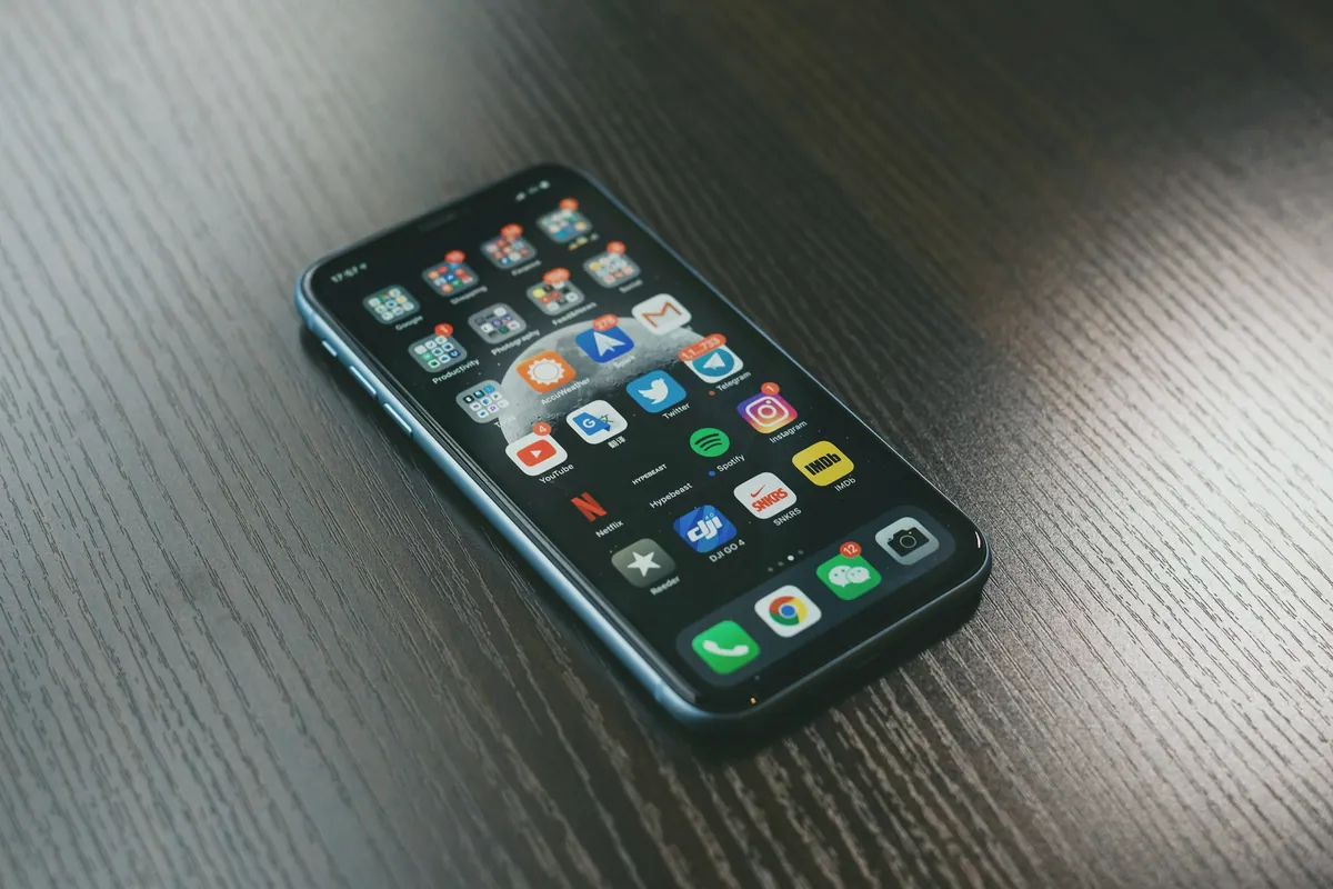 Smartphone lying face up on a dark wooden table