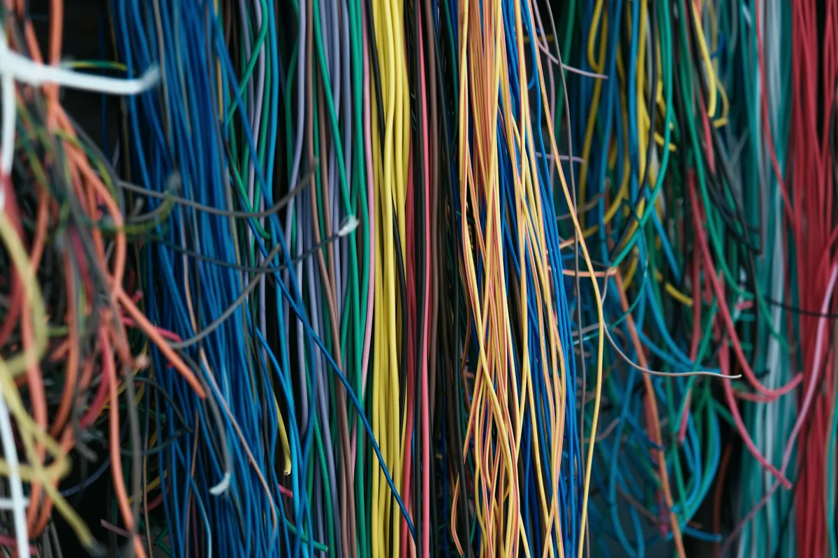 Dense bundle of multicolored wires hanging in tangled strands