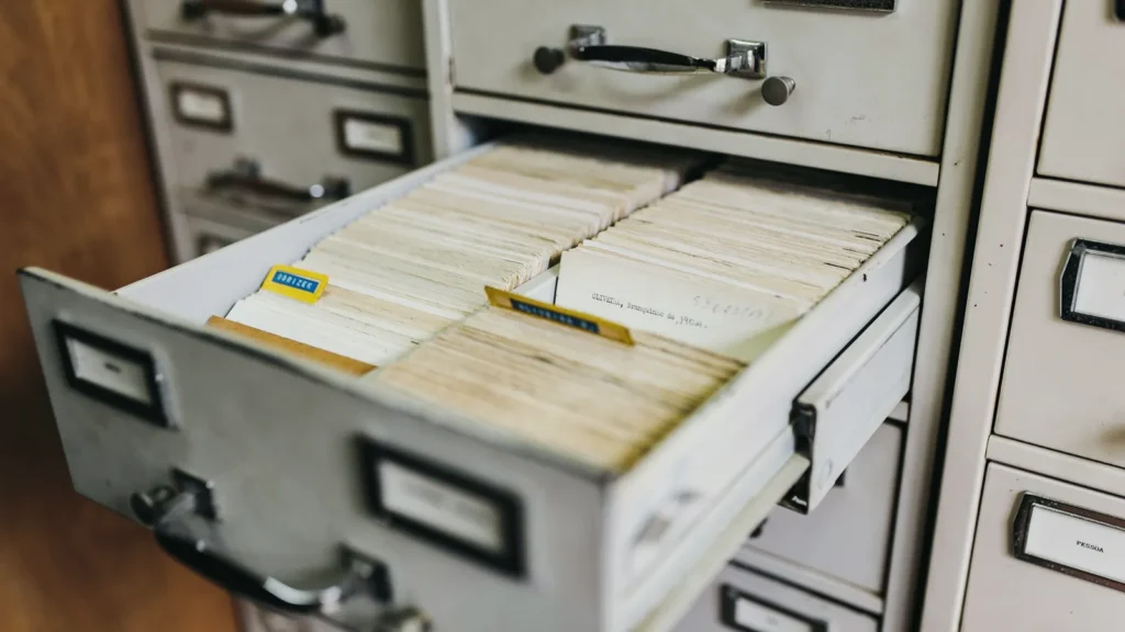 Open filing cabinet drawer packed with index cards