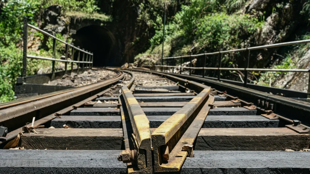 Railway switch with a lever where tracks diverge near a tunnel entrance