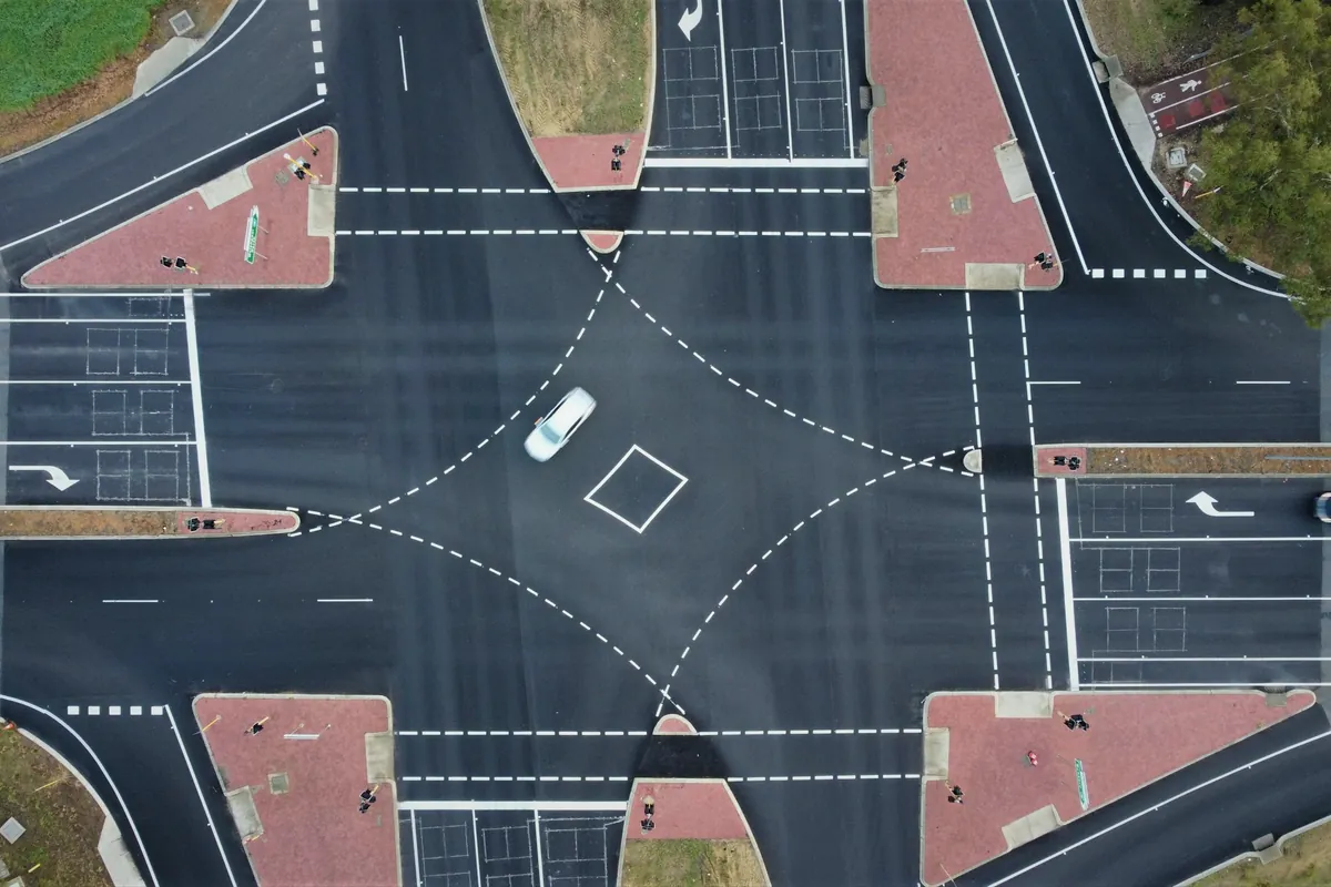 Aerial view of a road intersection with lane markings and turning lanes